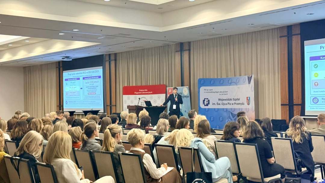 Ujęcie z tyłu na siedzących uczestników na sali konferencyjnej.