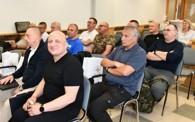 Siedzący na przeciw nich słuchacze w sali wykładowej.