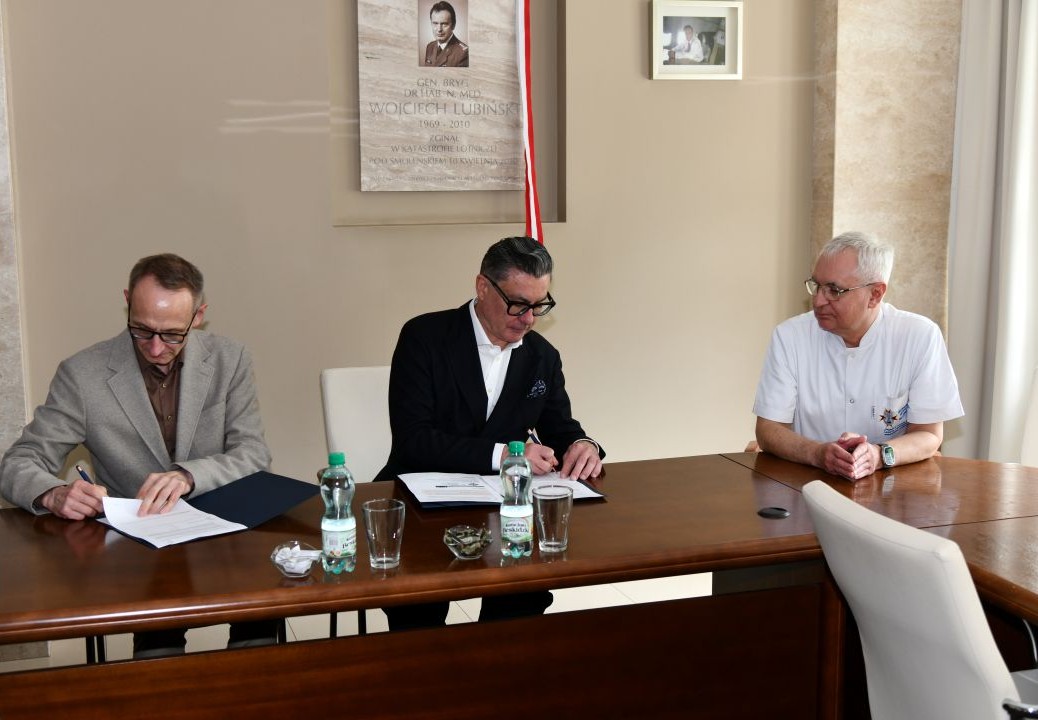 Dyrektor WIM i Cezary Kozanecki podpisują umowę obok nich siedzący Jacek Doniec.