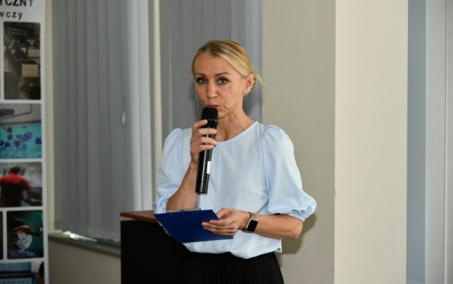 Małgorzata Złotkowska z mikrofonem w dłoni prowadzi uroczystość.