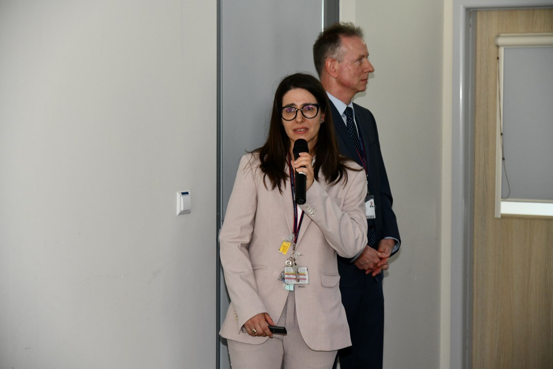 Justyna Chałubińska-Fendler z mikrofonem w ręku prowadzi prezentację.