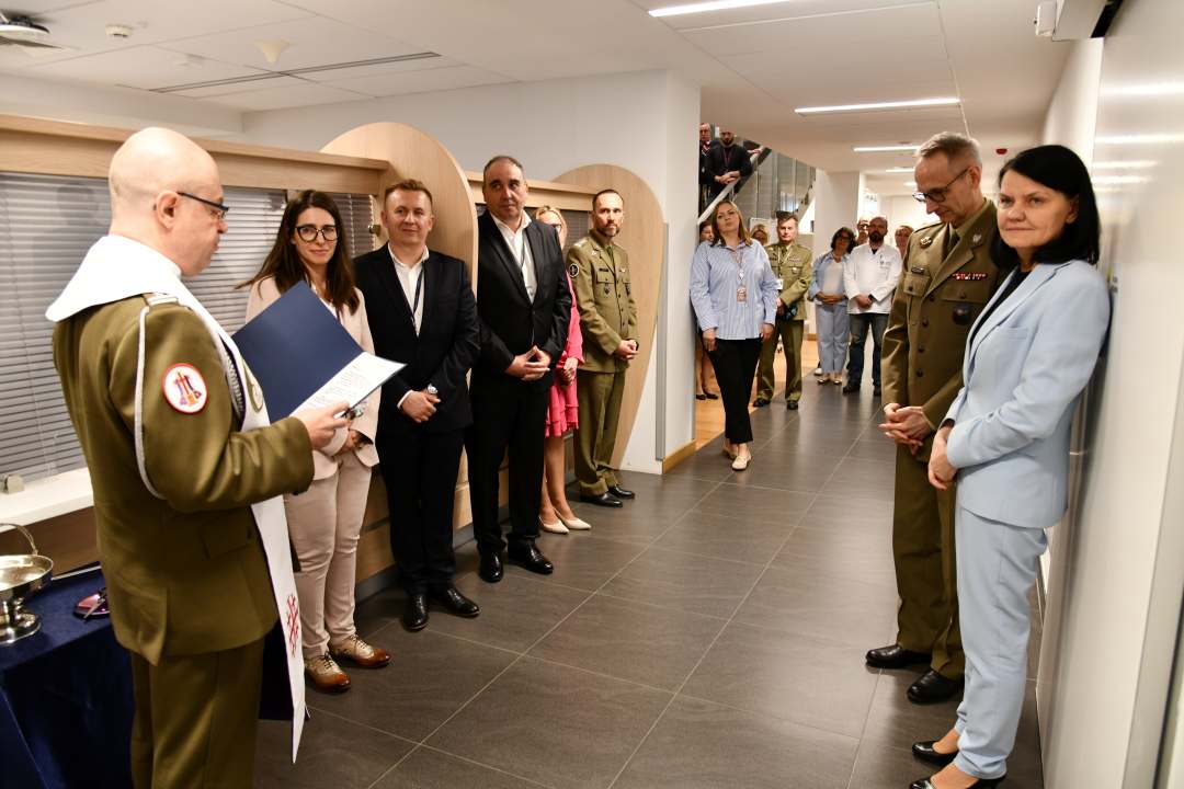 Kapelan wojskowy z gośćmi podczas poświęcenia nowych pomieszczeń.