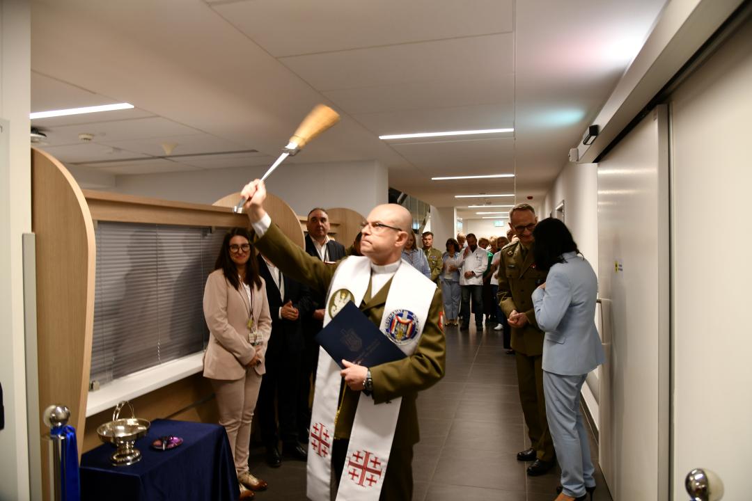 Kapelan wojskowy z kropidłem święci nowe pomieszczenia.