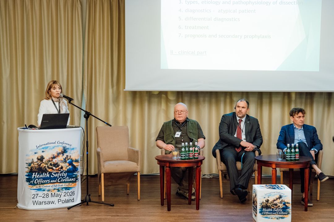 Katarzyna Gniadek przy mównicy, za nią ekran z wyświetlonym slajdem prezentacji oraz siedzący uczestnicy panelu konferencji.