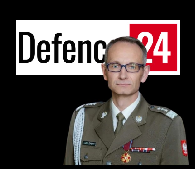 Grzegorz Gilerak, za nim logo defence24.