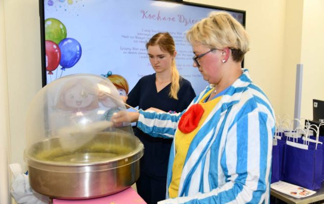 Dwie panie przy maszynie do robienia waty cukrowej robią watę.