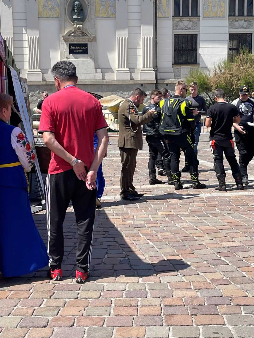 Mężczyzna stoi przy jednym z namiotów wystawienniczych na rynku krakowskim.