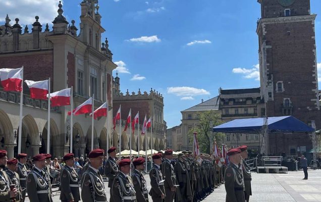 Żołnierze w strojach galowych podczas uroczystości stoją na rynku w Krakowie.