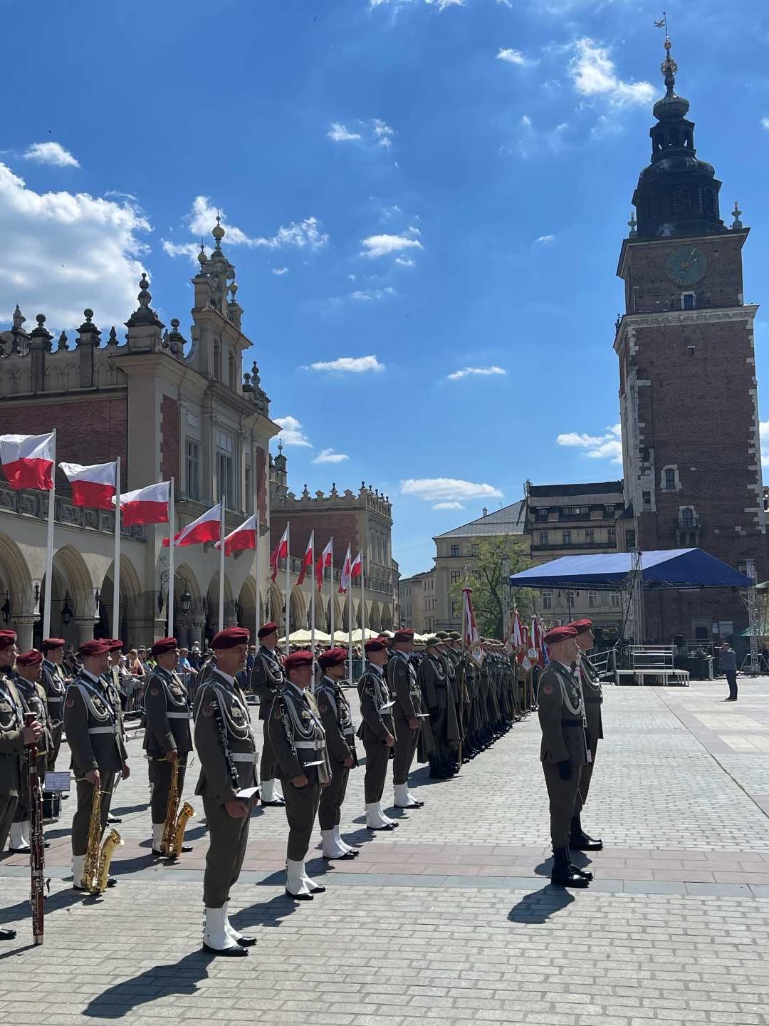 Żołnierze w strojach galowych podczas uroczystości stoją na rynku w Krakowie.