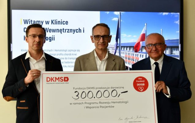 Dyrektor WIM-PIB, prof. Piotr Rzepecki i przedstawicie; Fundacji DKMS prezentują duży czek z wypisaną kwotą.