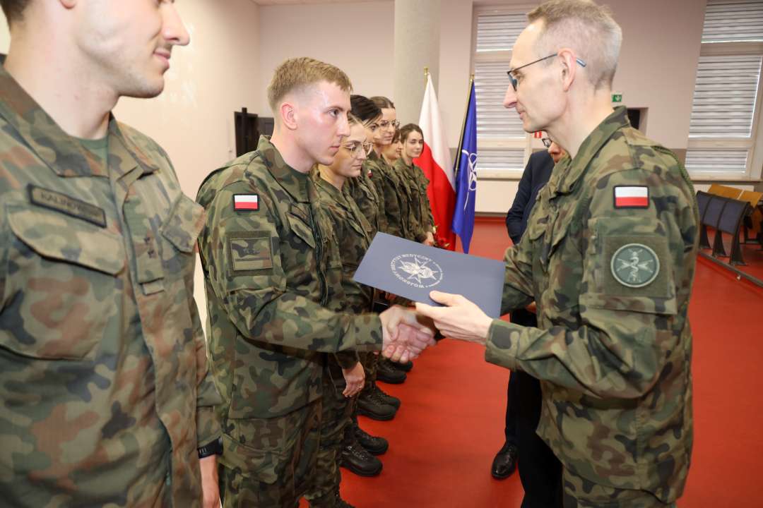 Dyrektor WIM gratuluje wyróżnionym lekarzom ubranym w mundury wojskowe.