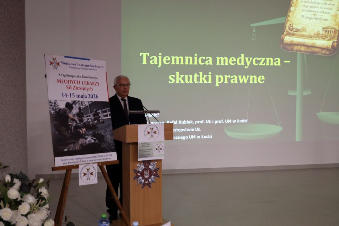 Profesor Rafał Kubiak przy mównicy za jego plecami wyświetlony slajd prezentacji z napisem Tajemnica medyczna - skutki prawne.
