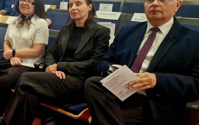 Siedzący słuchacze i goście na sali konferencyjnej.