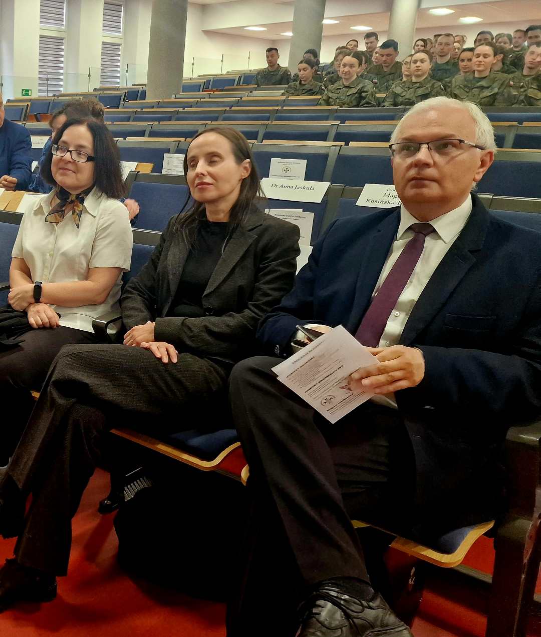 Siedzący słuchacze i goście na sali konferencyjnej.