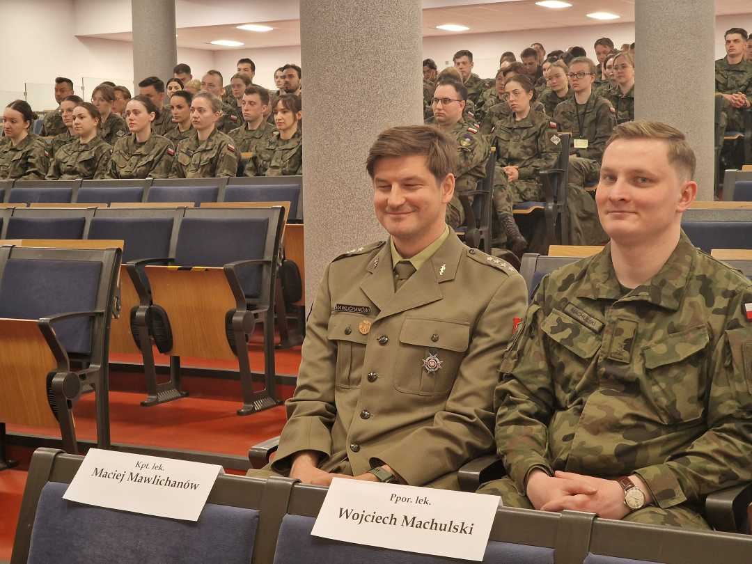 Siedzący lekarze w mundurach wojskowych na sali konferencyjnej,