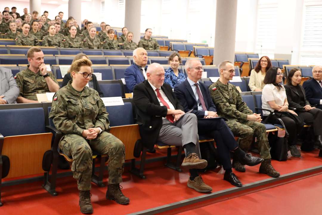 Siedzący słuchacze i goście na sali konferencyjnej.