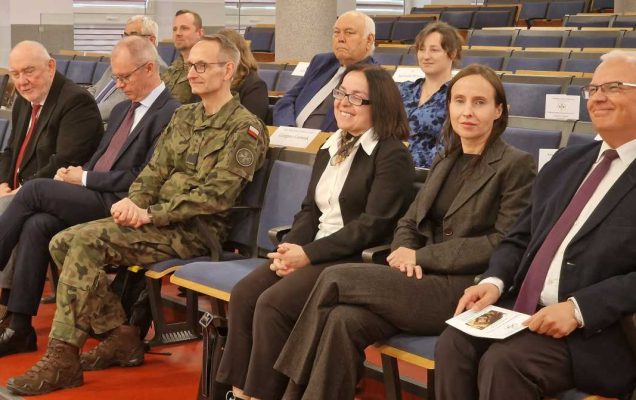 Siedzący goście - wykładowcy na sali konferencyjnej.