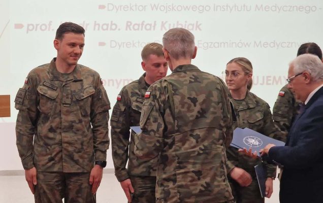 Sala konferencyjna, Dyrektor WIM i Dyrektor CEM wręczają listy gratulacyjne lekarzom w strojach wojskowych.