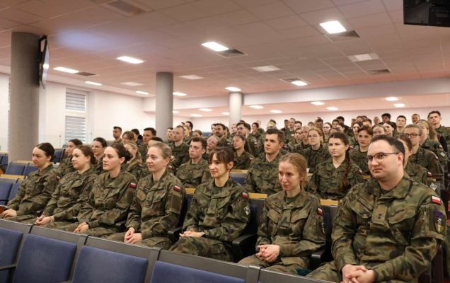 Siedzący lekarze w mundurach wojskowych na sali konferencyjnej.