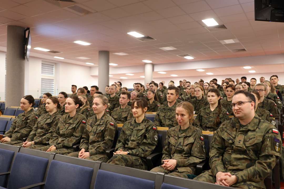 Siedzący lekarze w mundurach wojskowych na sali konferencyjnej.