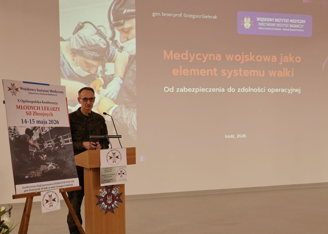 Dyrektor WIM przy mównicy, za jego plecami na ekranie slajd z prezentacji pt. Medycyna wojskowa jako element systemu walki,