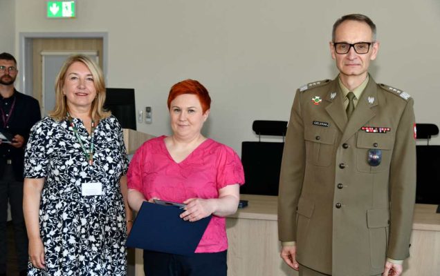 Grzegorz Gielerak i Marta Maciążek pozują z absolwentką trzymającą dyplom w rękach.