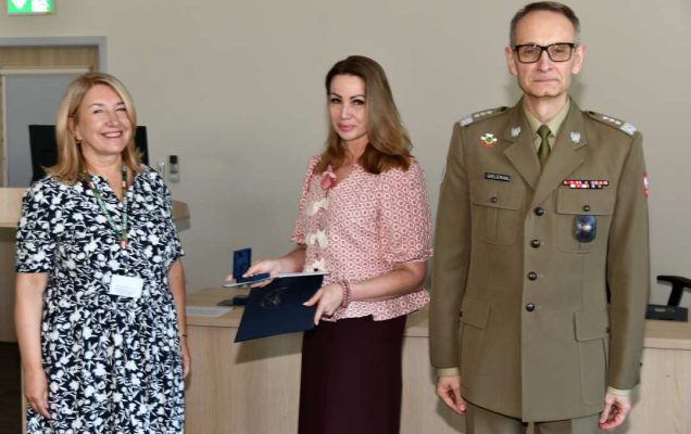 Grzegorz Gielerak i Marta Maciążek pozują z absolwentką stojącą pomiędzy nimi. Kobieta trzyma w rękach dyplom.