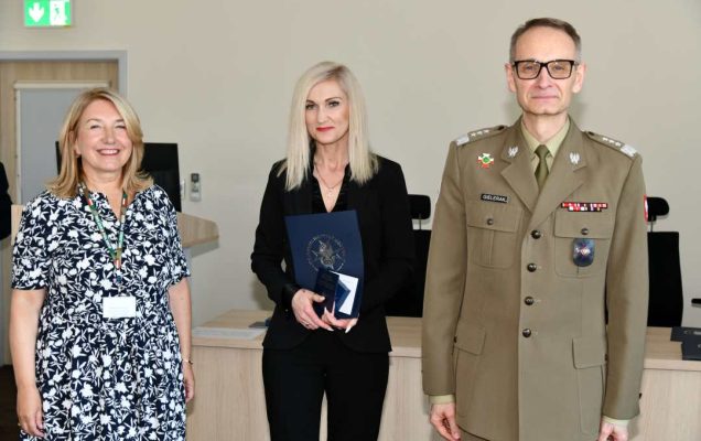 Grzegorz Gielerak i Marta Maciążek pozują z absolwentką stojącą pomiędzy nimi. Kobieta trzyma w rękach dyplom.