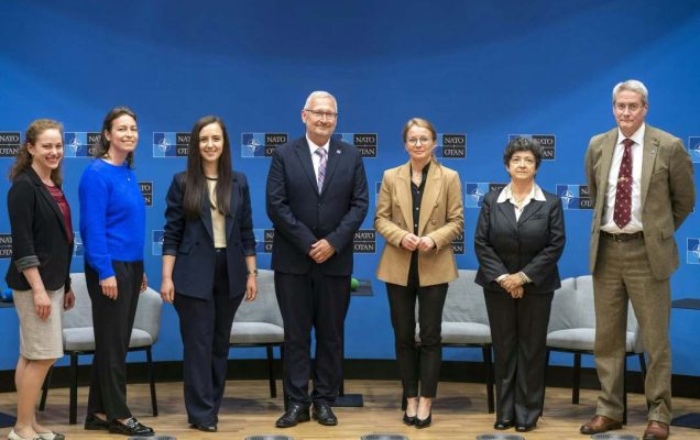 Przedstawiciele WIM pozują do zdjęcia, za ich plecami logotypy konferencji na niebieskim tle.