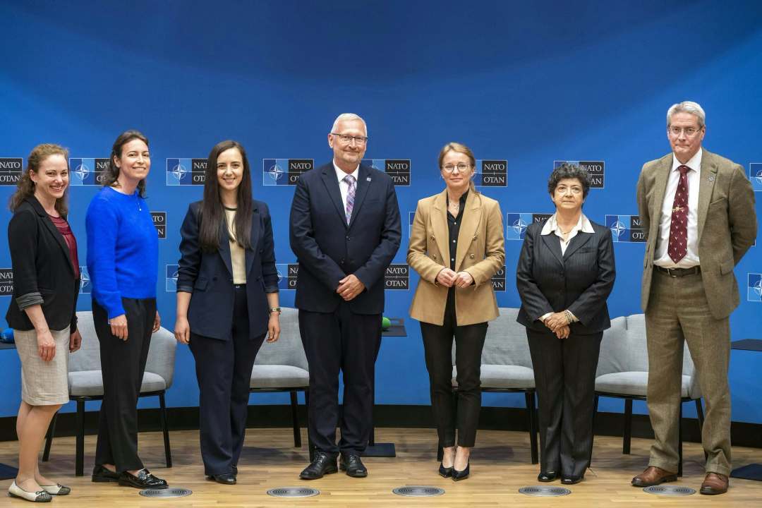 Przedstawiciele WIM pozują do zdjęcia, za ich plecami logotypy konferencji na niebieskim tle.
