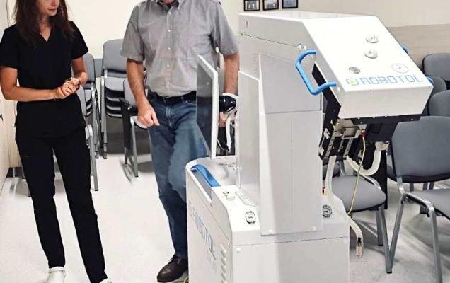 Pracowniczka i pracownik kliniki oglądają nowego robota.