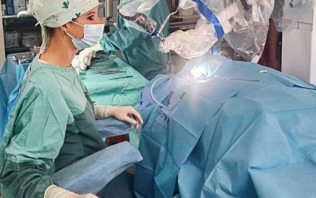 Chirurżka przy konsoli robota w trakcie operacji robotycznej.