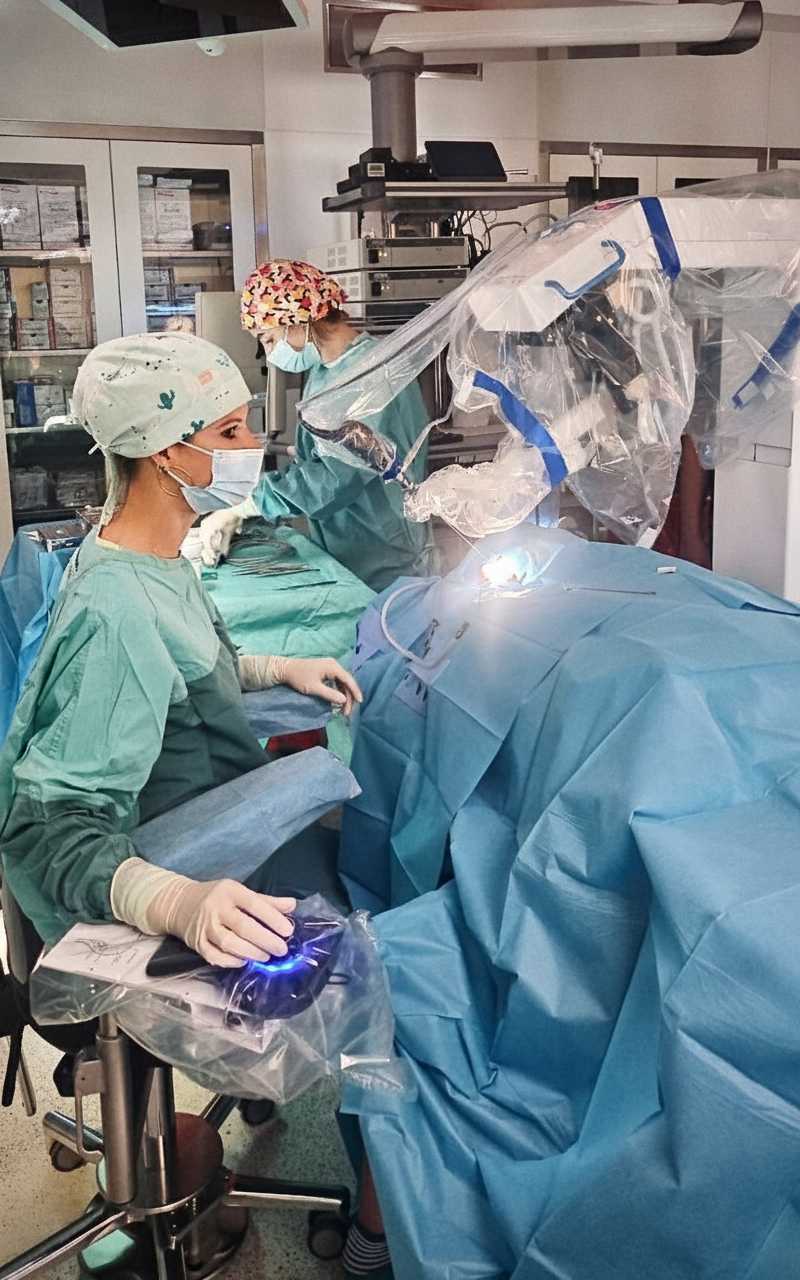 Chirurżka przy konsoli robota w trakcie operacji robotycznej.
