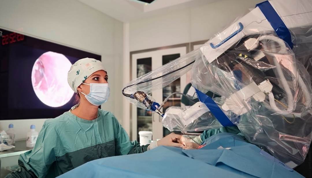 Chirurżka przy konsoli robota w trakcie operacji robotycznej.