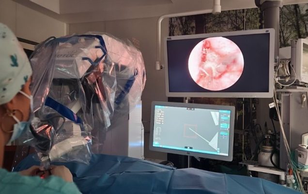 Chirurg przy konsoli robota w trakcie operacji robotycznej.