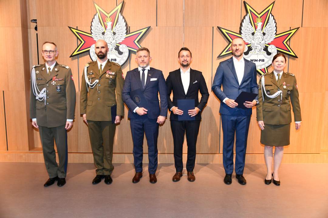Wyróżnieni pracownicy WIM pozują do zdjęcia z dyrektorem WIM.