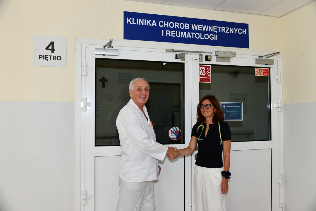 Pod wejściem do Kliniki Chorób Wewnętrznych i Reumatologii, prof. dr. hab. n. med. Witold Tłustochowicz podaje rękę dr hab. n. med. Ewie Więsik-Szewczyk przekazując jej swoje obowiązki.